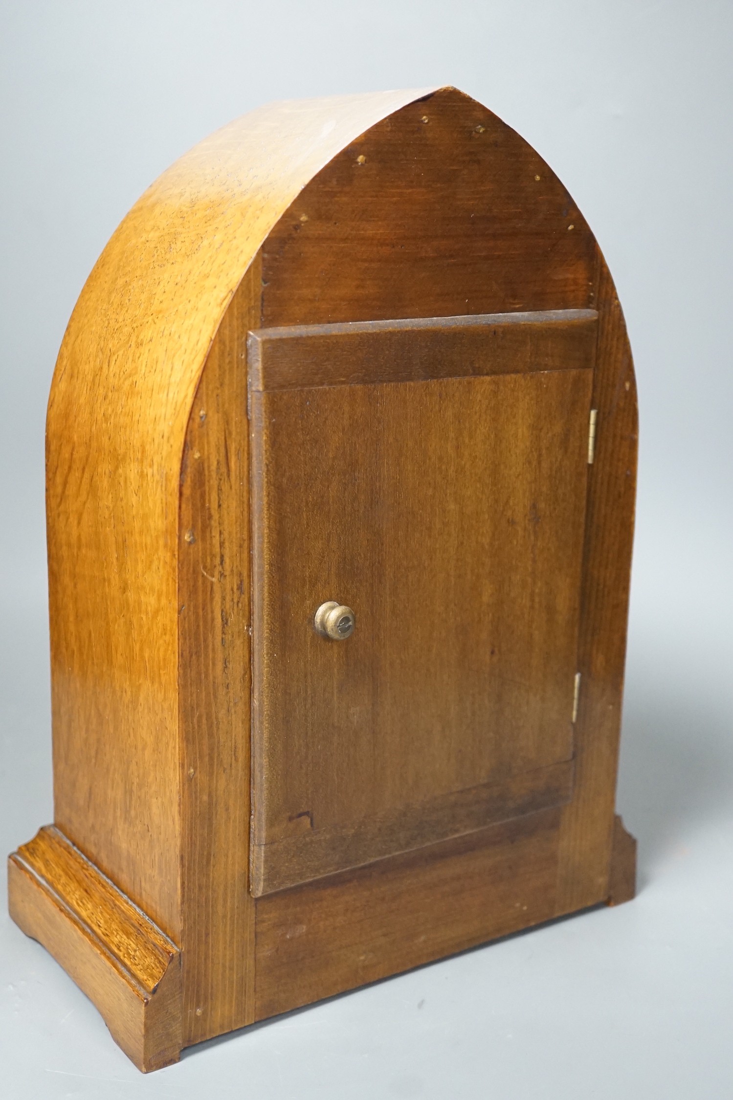 A pair of ebony rhinoceros book ends, together with an Edwardian oak lancet mantel clock, 35cm high